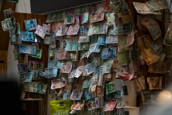 Image of many different currencies fluttering in the wind. Photo by EVERFOCAL on Unsplash